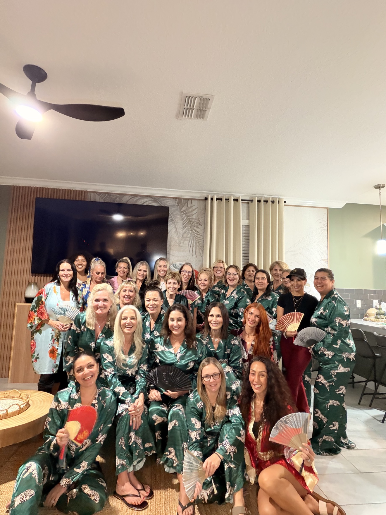 Large group of party guests in matching pajamas with fans at a hibachi celebration