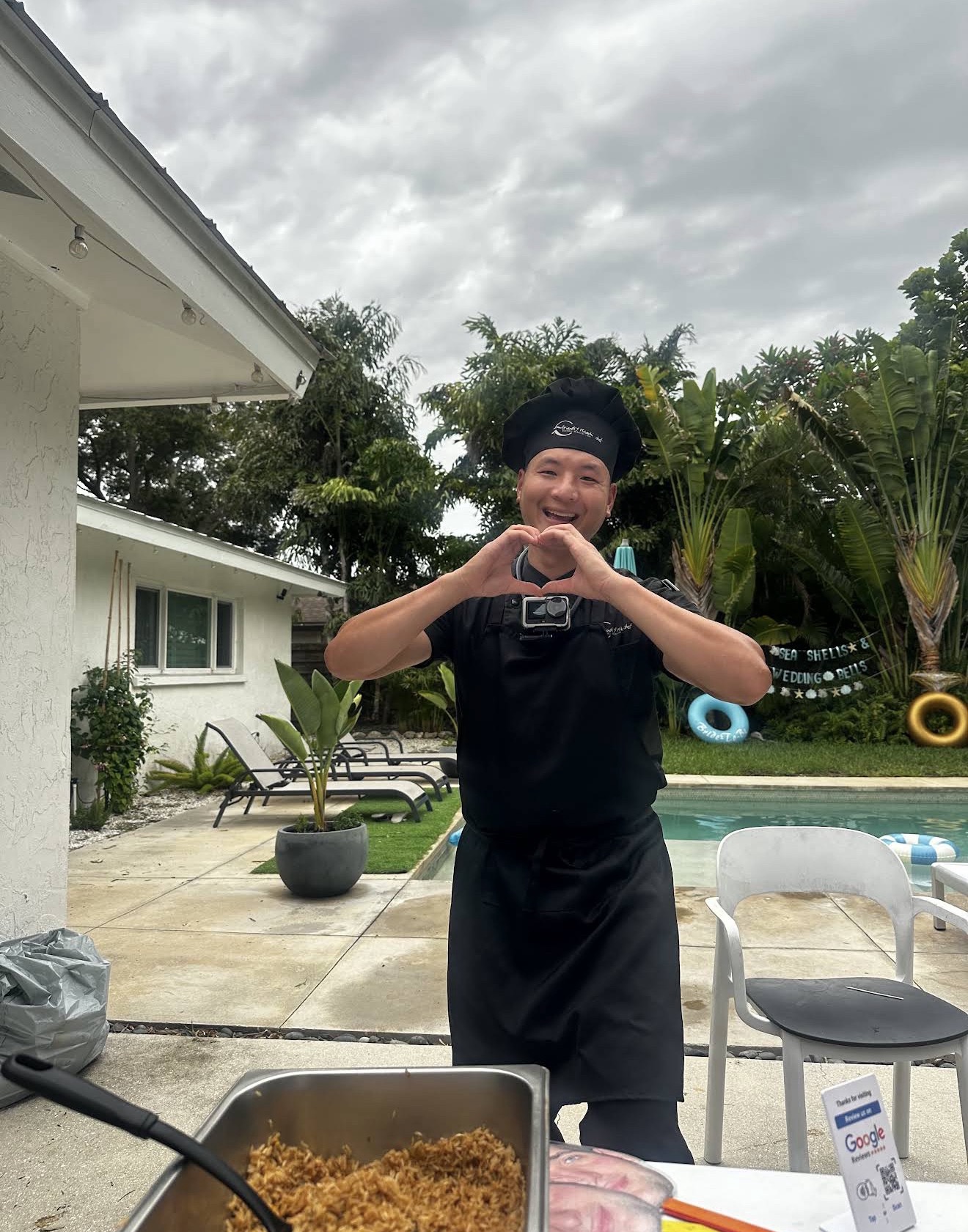 Chef making a heart sign at a poolside party in Riverview